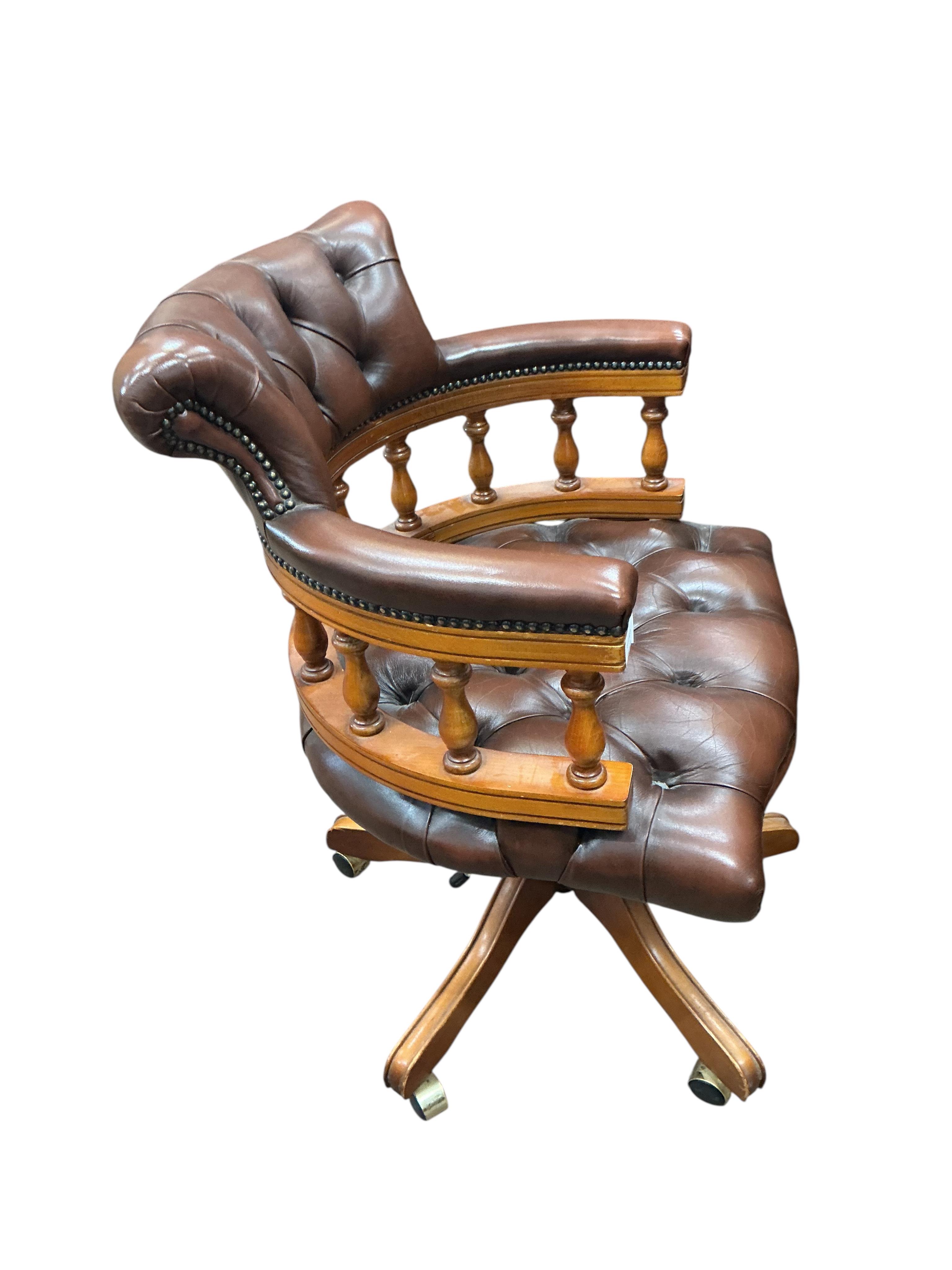 A reproduction mahogany and buttoned brown leather swivel desk chair, width 61cm, height 88cm